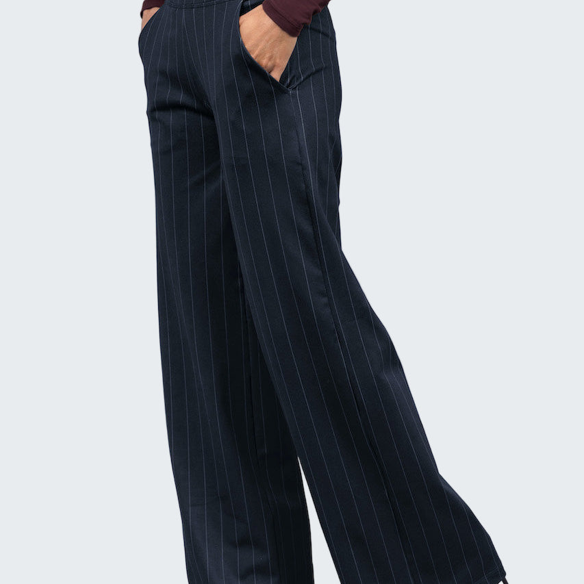 Navy pinstripe pants worn by a person on a light gray background
