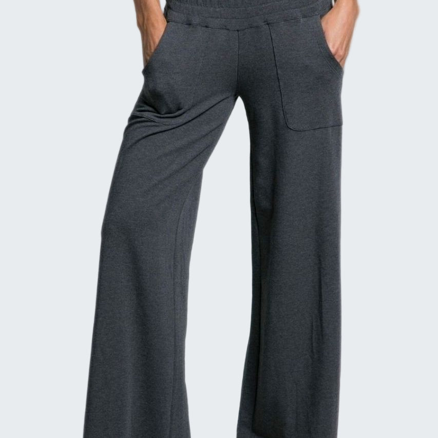 Person wearing dark gray wide-leg pants on a plain background