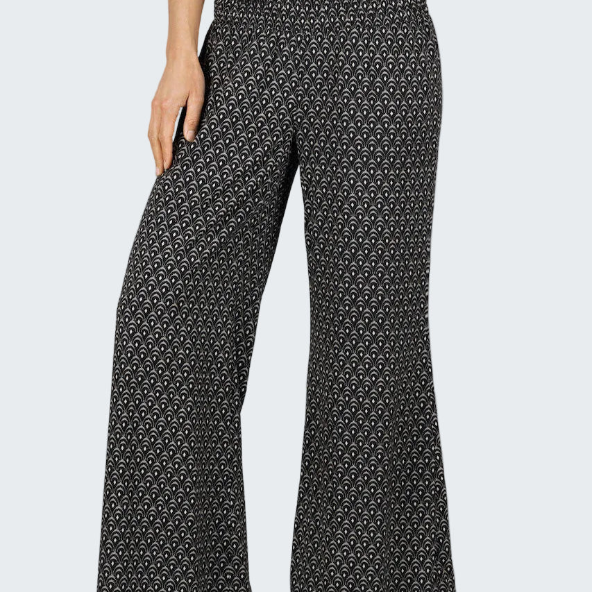 Black patterned pants worn by a person on a gray background