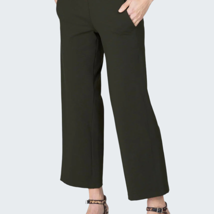 Person wearing black pants on a gray background
