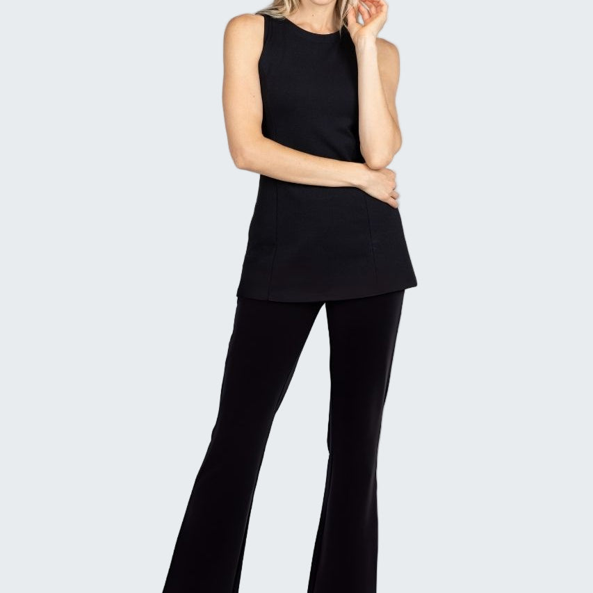 Woman wearing a black sleeveless top and black flared pants on a white background
