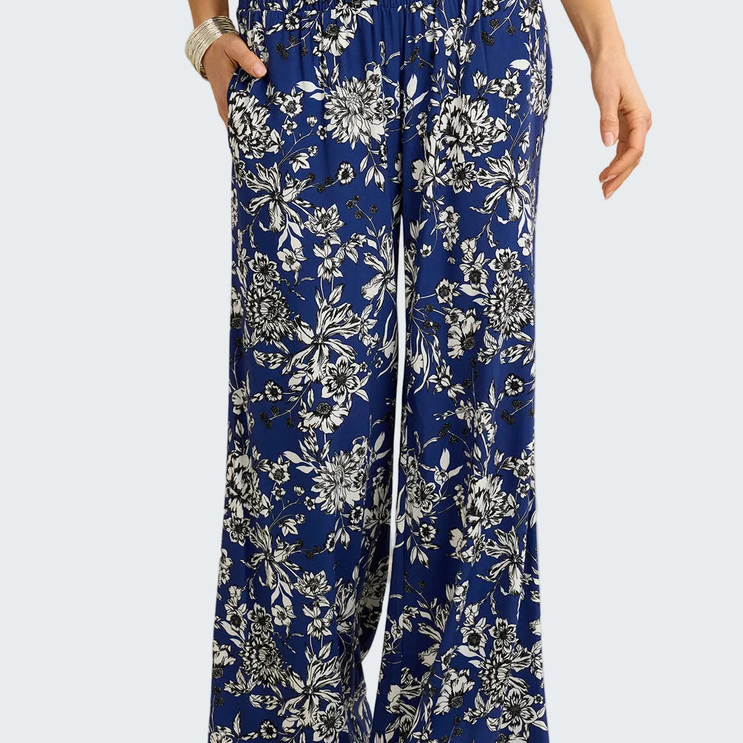 Blue floral-patterned pants worn by a person on a beige background