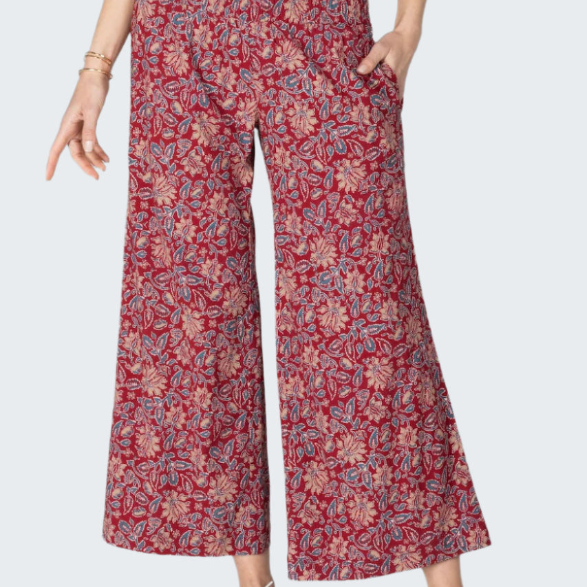 Person wearing red floral-patterned pants on a gray background