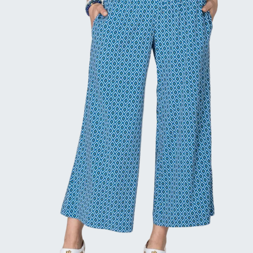 Person wearing blue patterned pants on a beige background