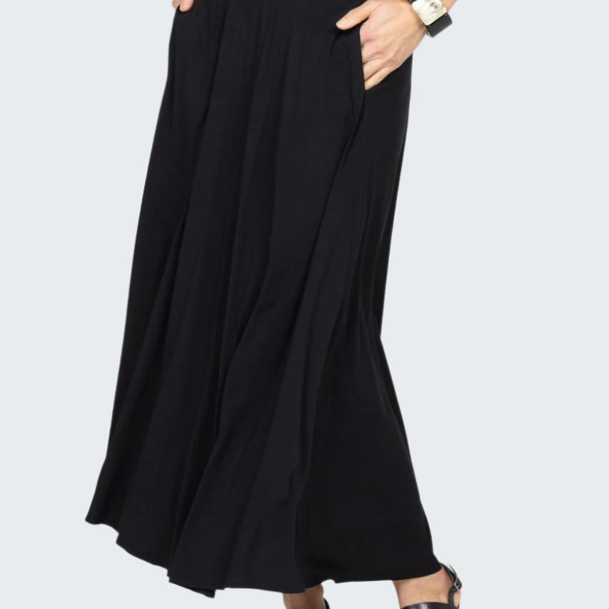 Person wearing a black skirt on a gray background