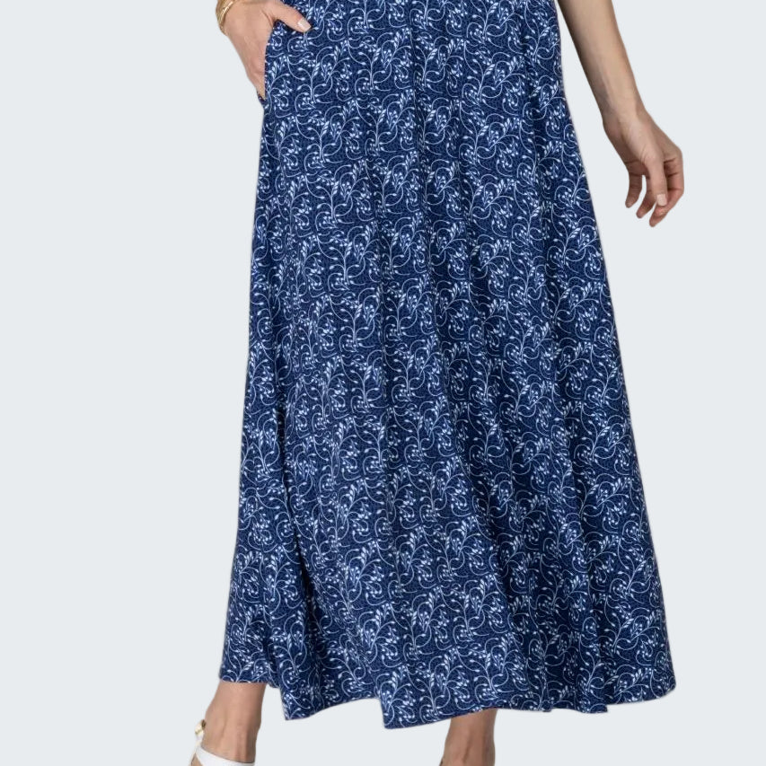 Woman wearing a blue floral skirt on a beige background