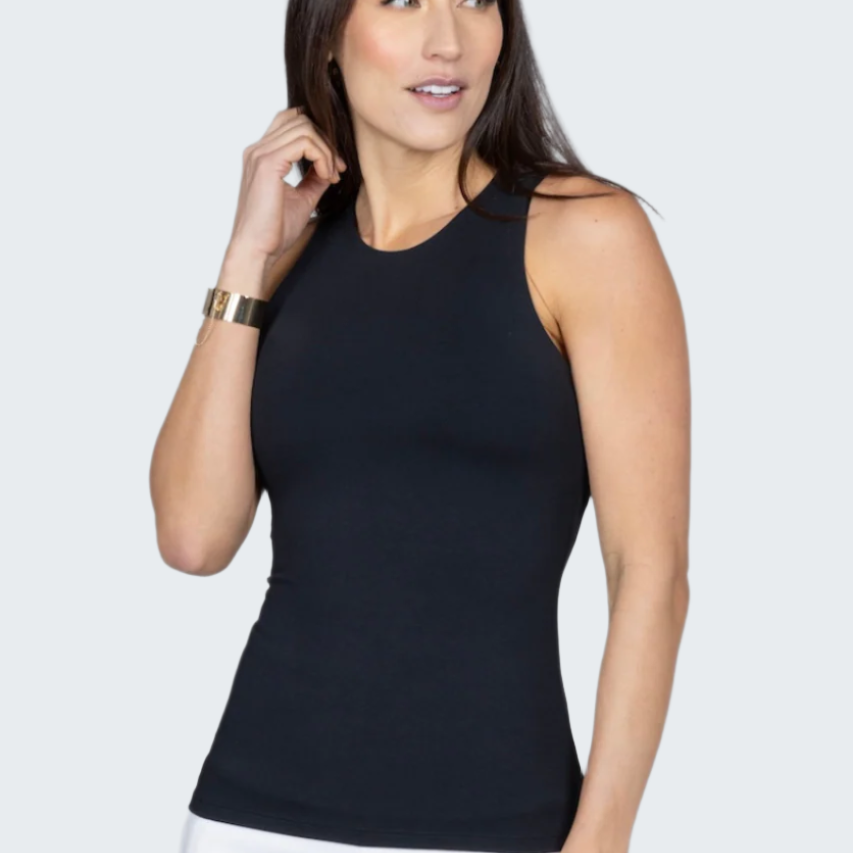 Woman wearing a black sleeveless top and white pants against a gray background