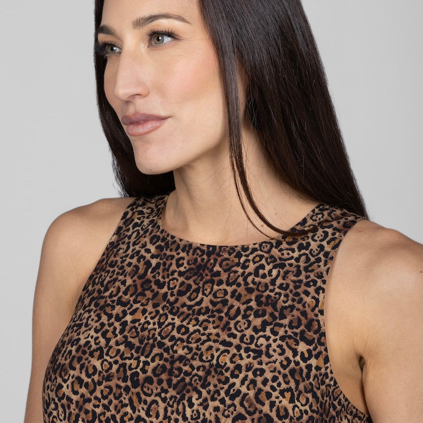 Woman wearing a leopard print top against a gray background