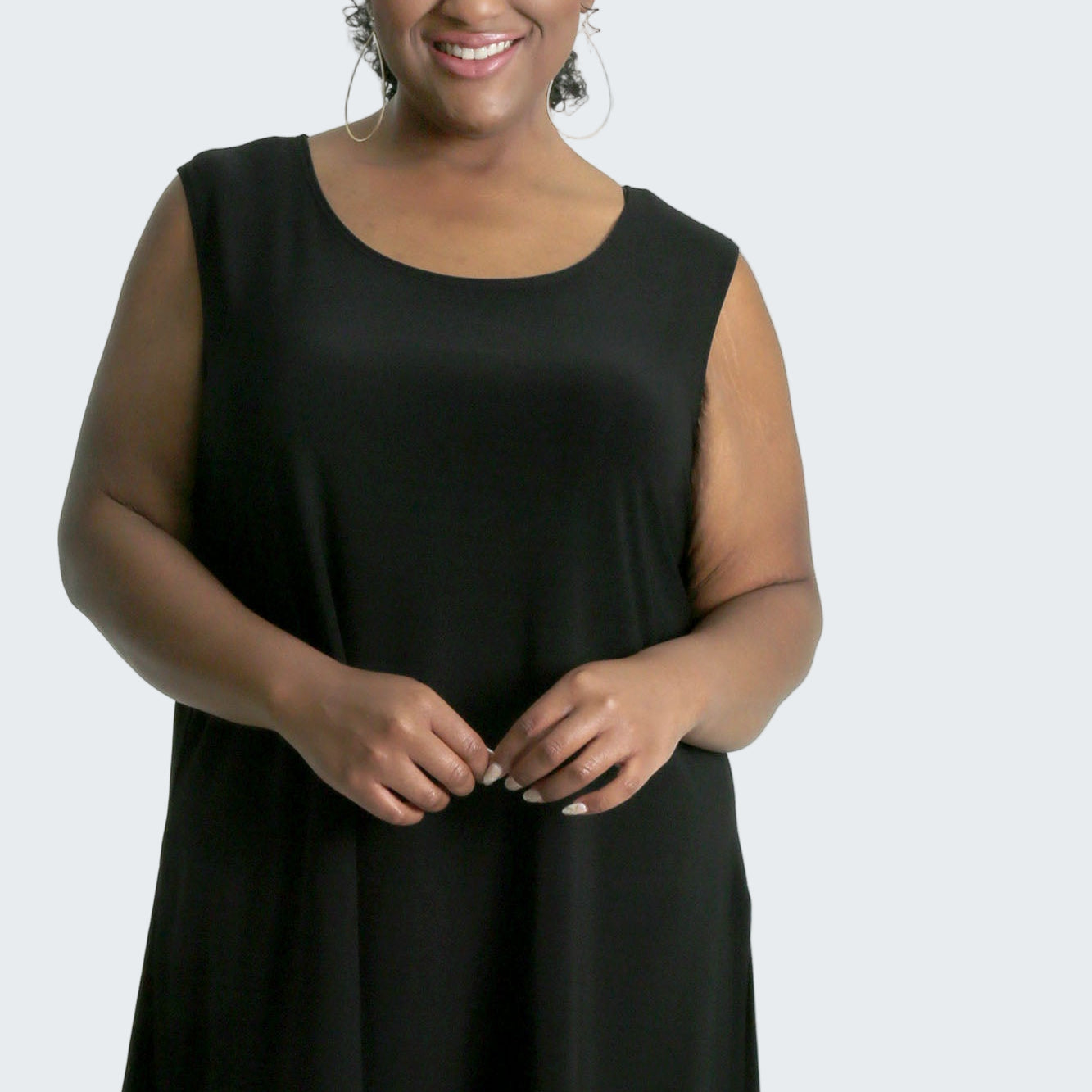 Woman wearing a black sleeveless top on a white background