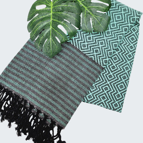 Two patterned cloths with green leaves on a white background