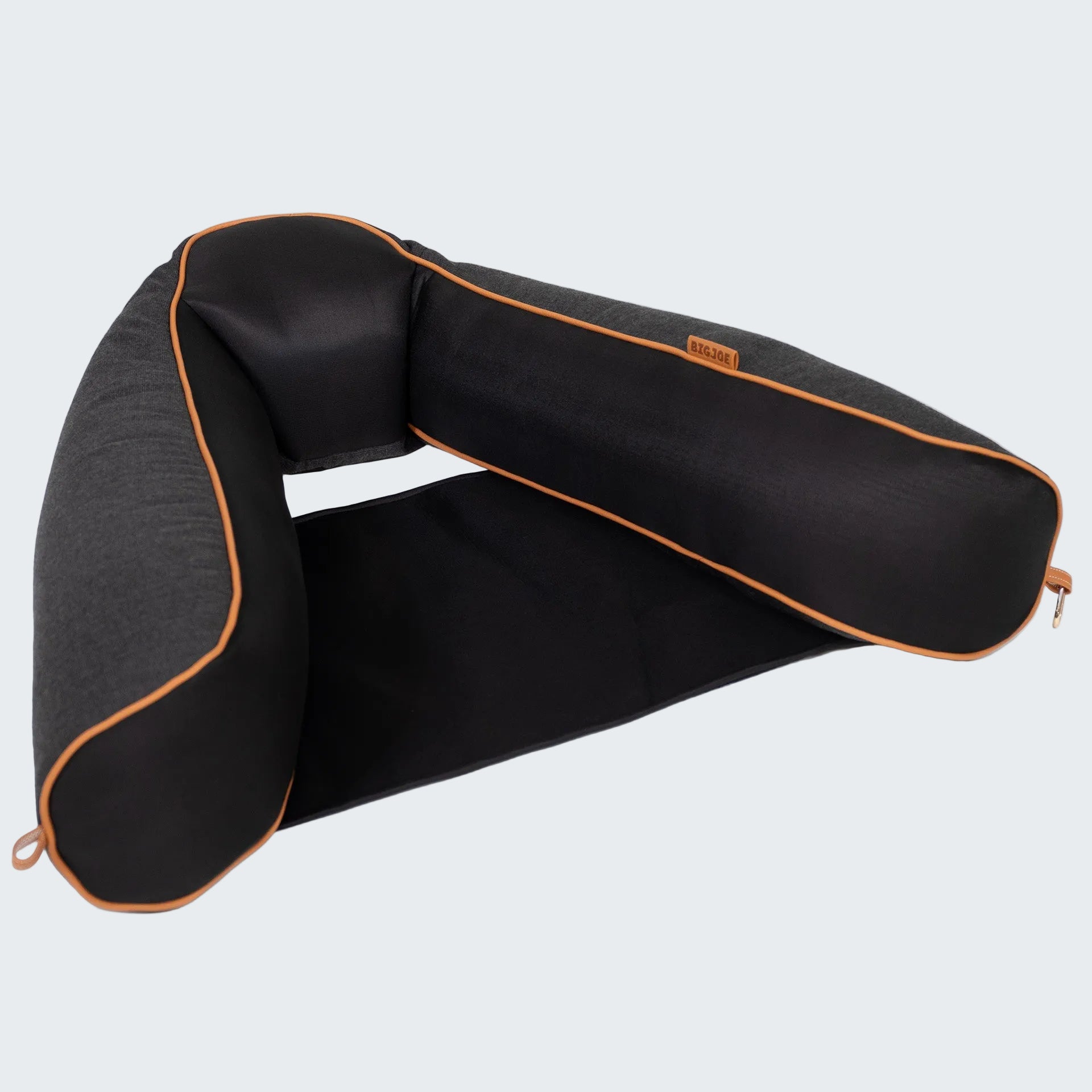 Black travel pillow with orange accents on a white background