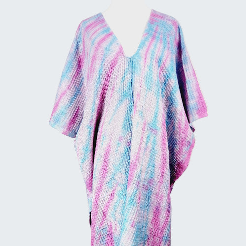 Colorful poncho with pink and blue patterns on a white background