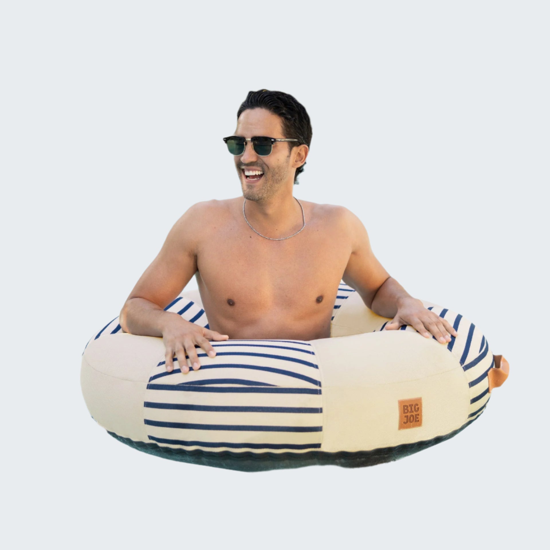 Man in sunglasses sitting on a striped inflatable tube in a pool