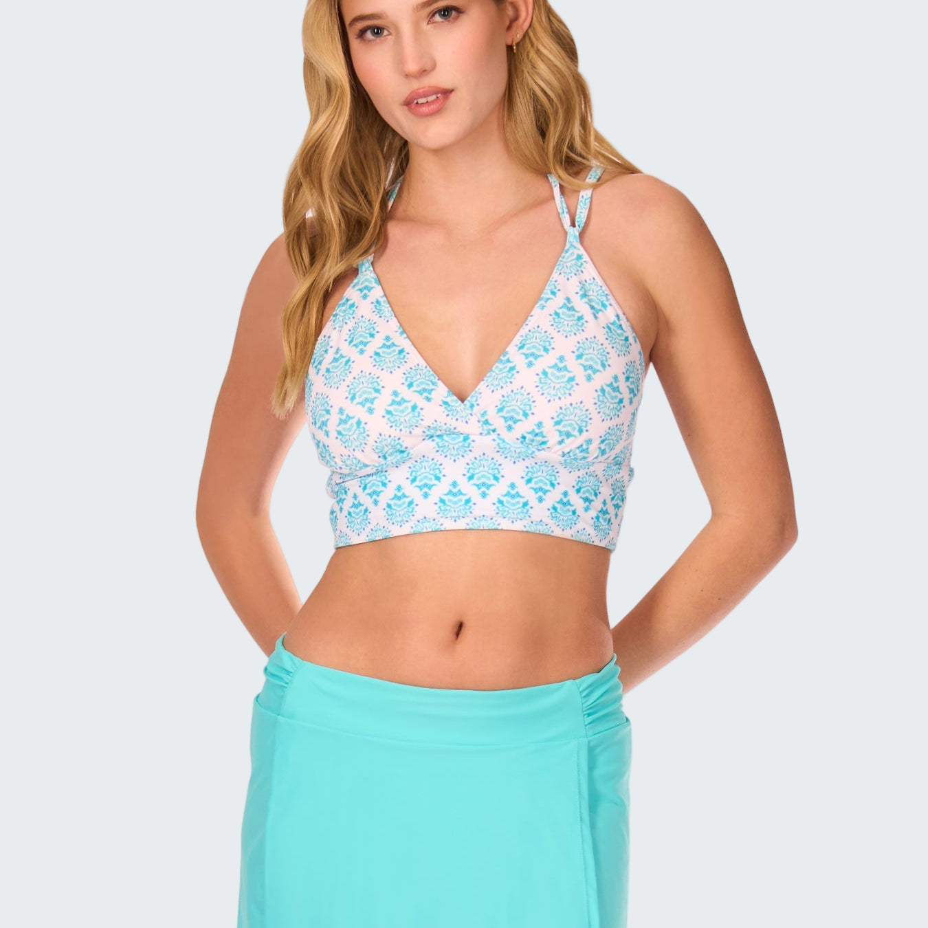 Woman wearing a light blue patterned top and matching skirt on a white background