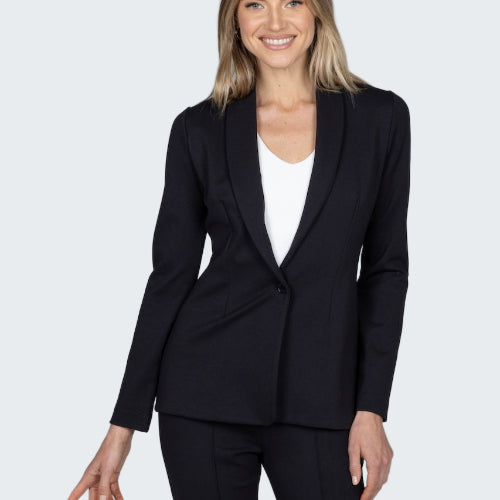 Woman wearing a black suit jacket and pants on a gray background