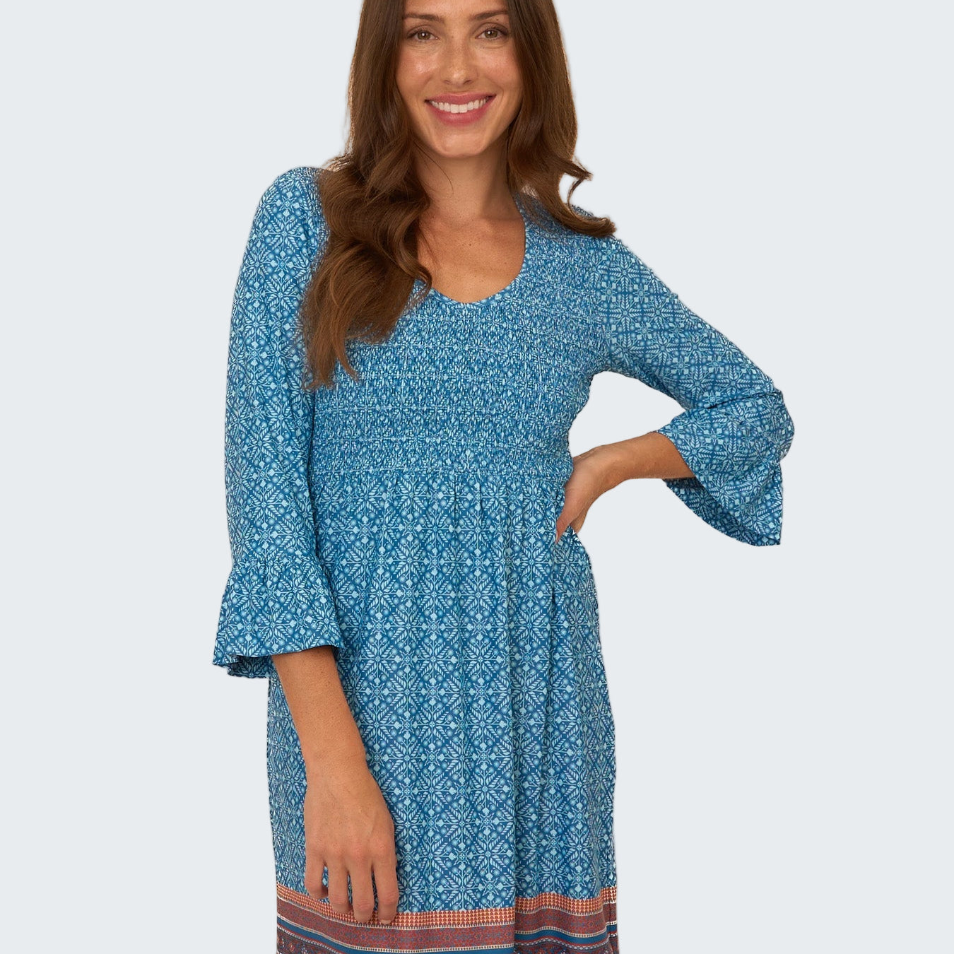 Woman wearing a blue patterned dress on a white background
