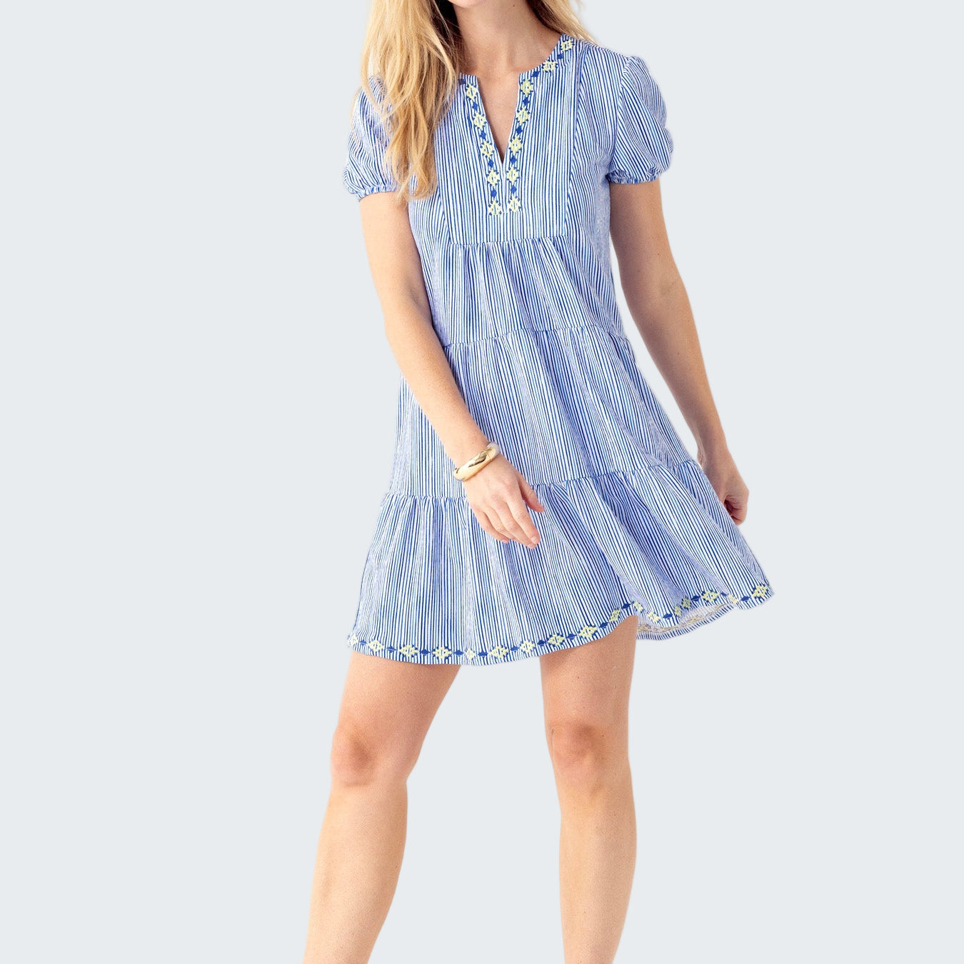 Woman wearing a blue and white striped dress on a white background