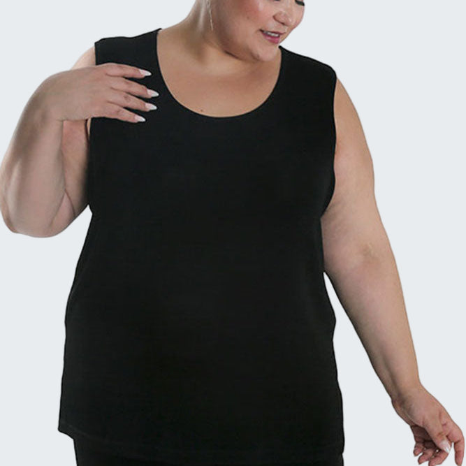 Woman wearing a black sleeveless top and pants on a white background