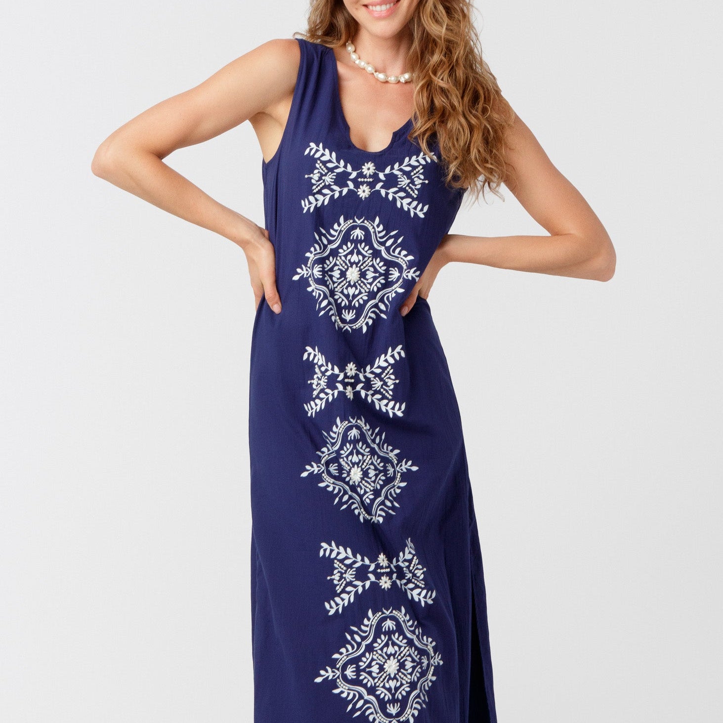 Woman wearing a blue dress with white patterns on a white background