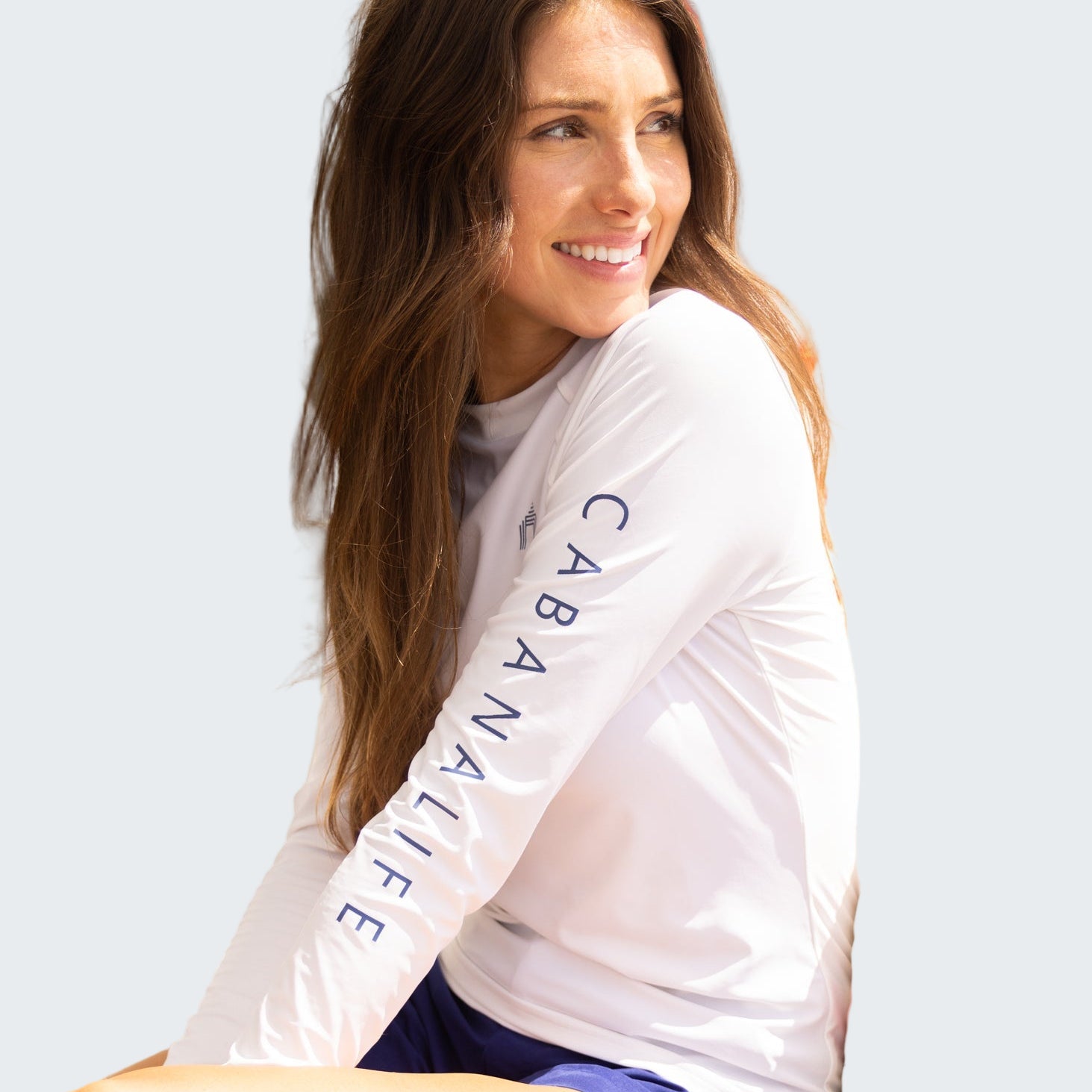Woman wearing a 'Cabana Life' shirt sitting on a boat.