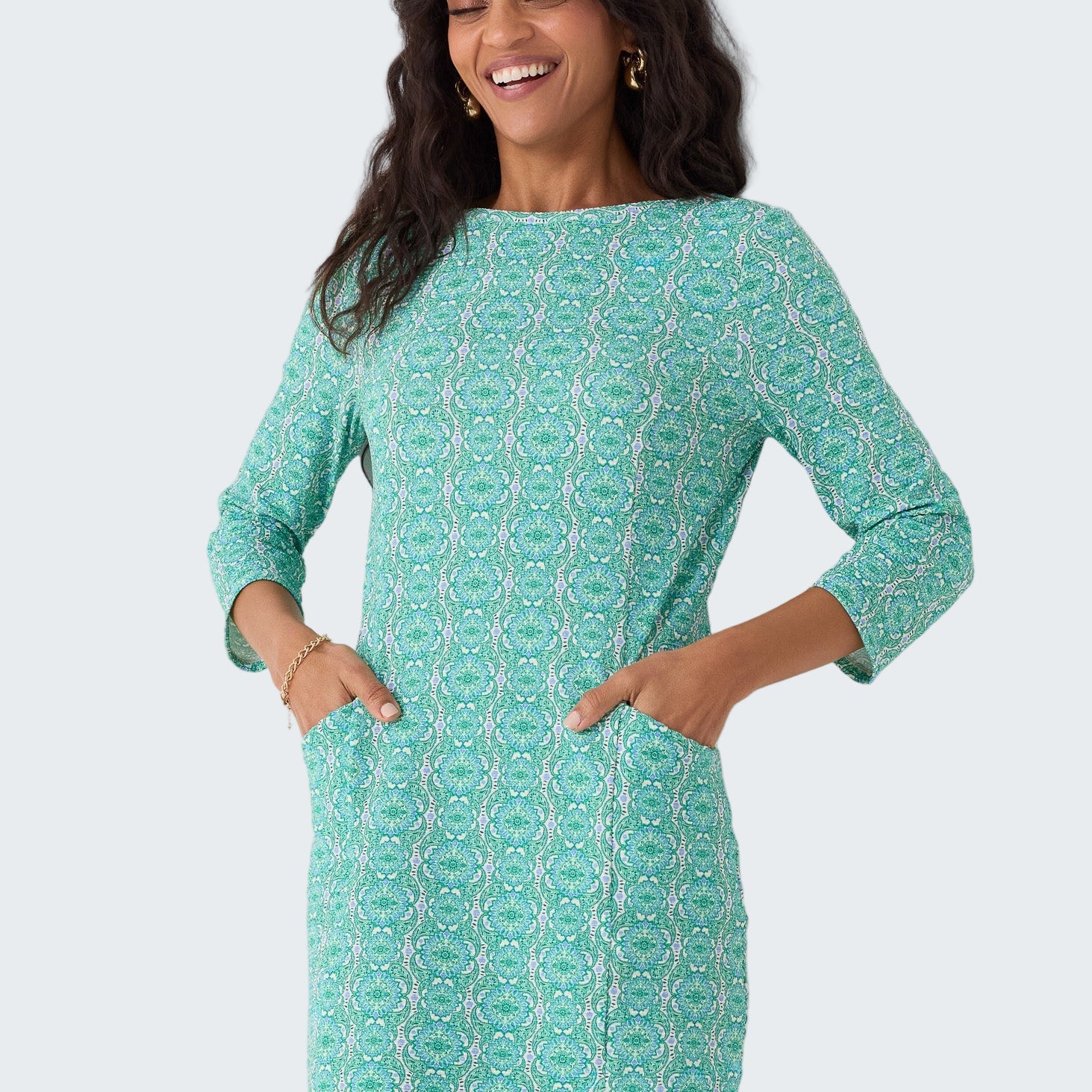 Woman wearing a green patterned dress against a white background