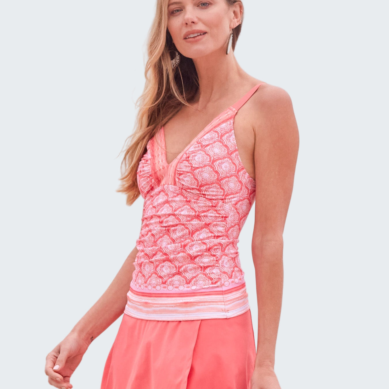 Woman wearing a pink swimsuit with ocean in the background