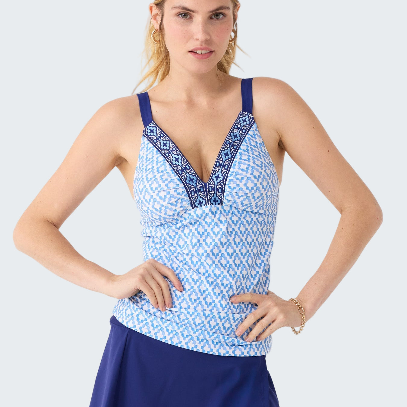 Woman wearing a blue and white patterned tank top with a matching skirt on a white background