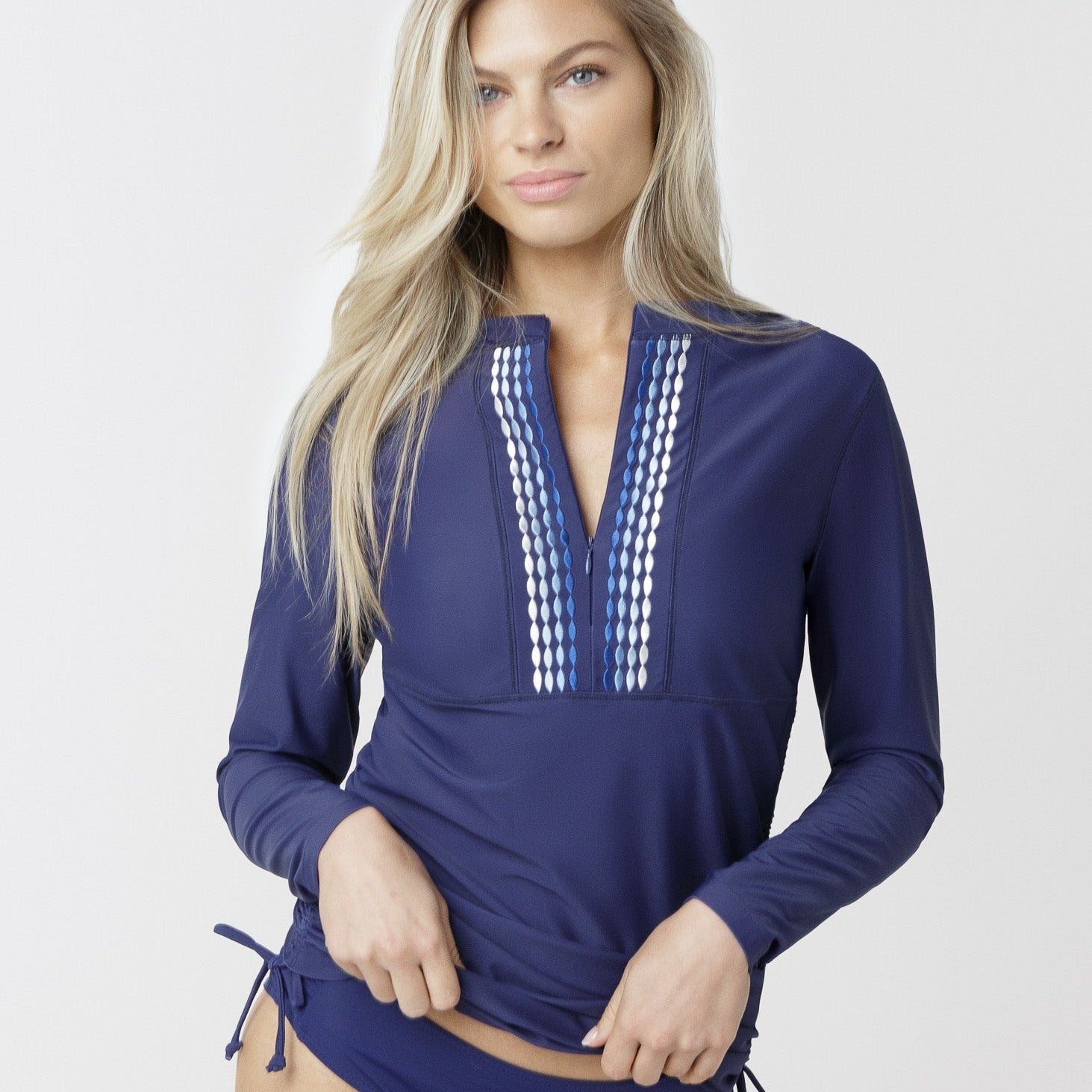 Woman wearing a blue swimsuit with long sleeves on a white background