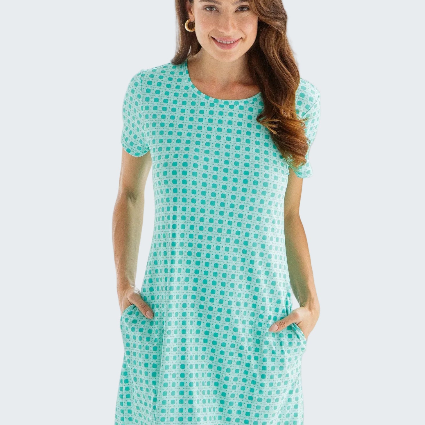Woman wearing a turquoise checkered dress against a white background