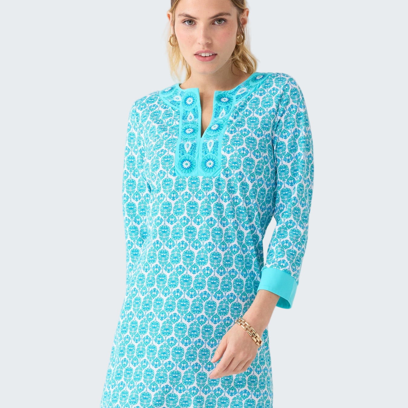 Woman wearing a blue patterned dress on a white background