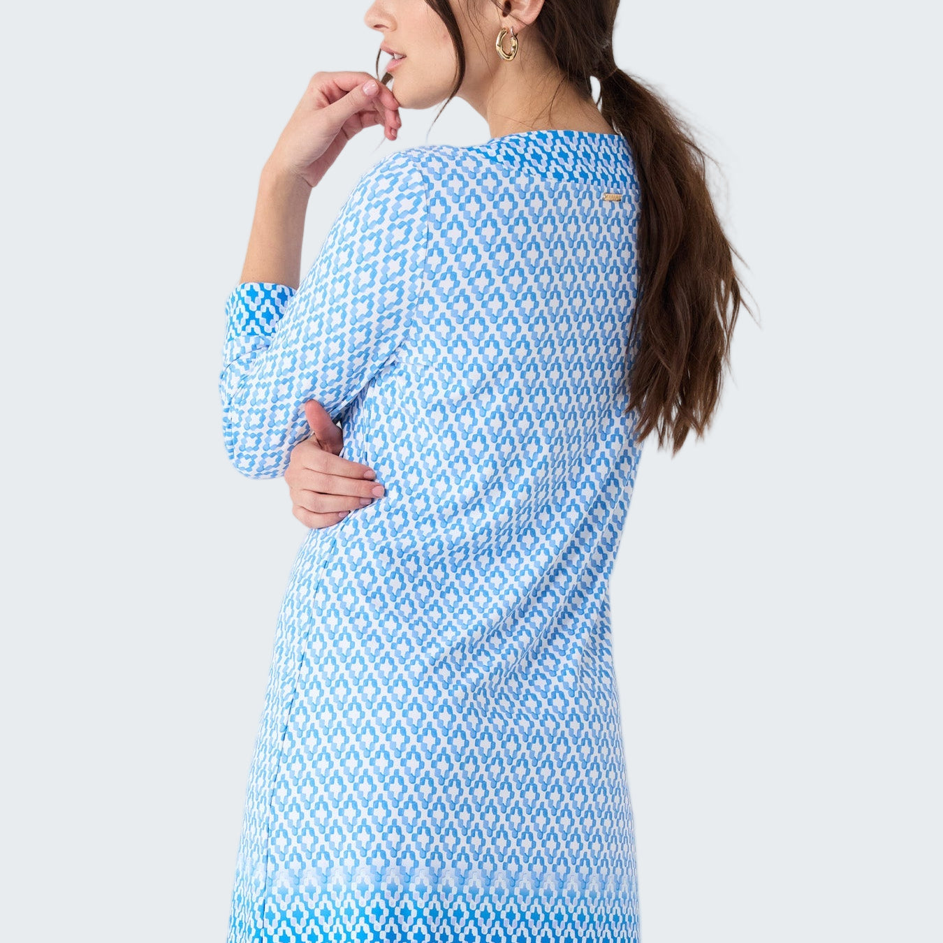 Woman wearing a blue patterned dress on a white background