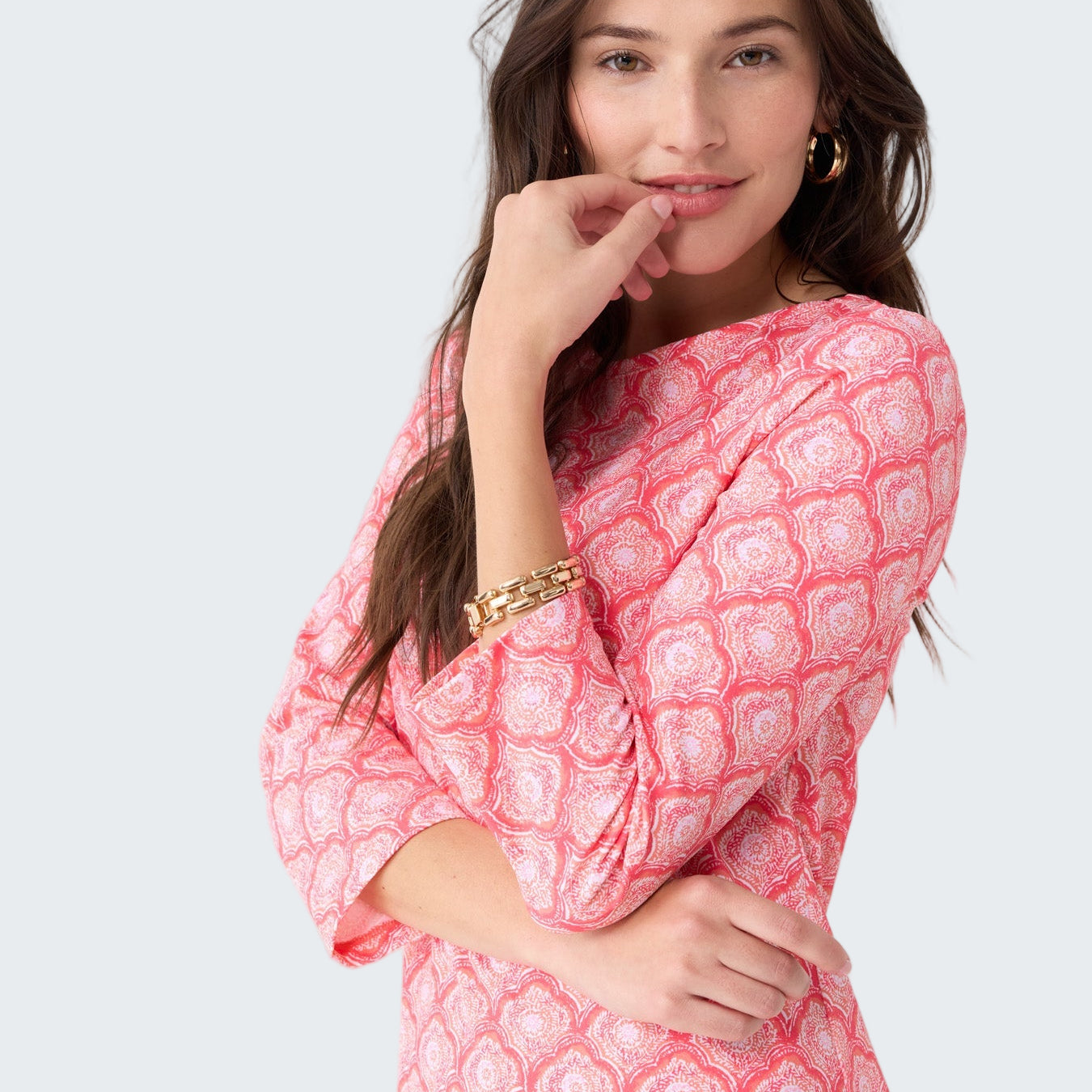 Woman wearing a pink patterned dress on a white background