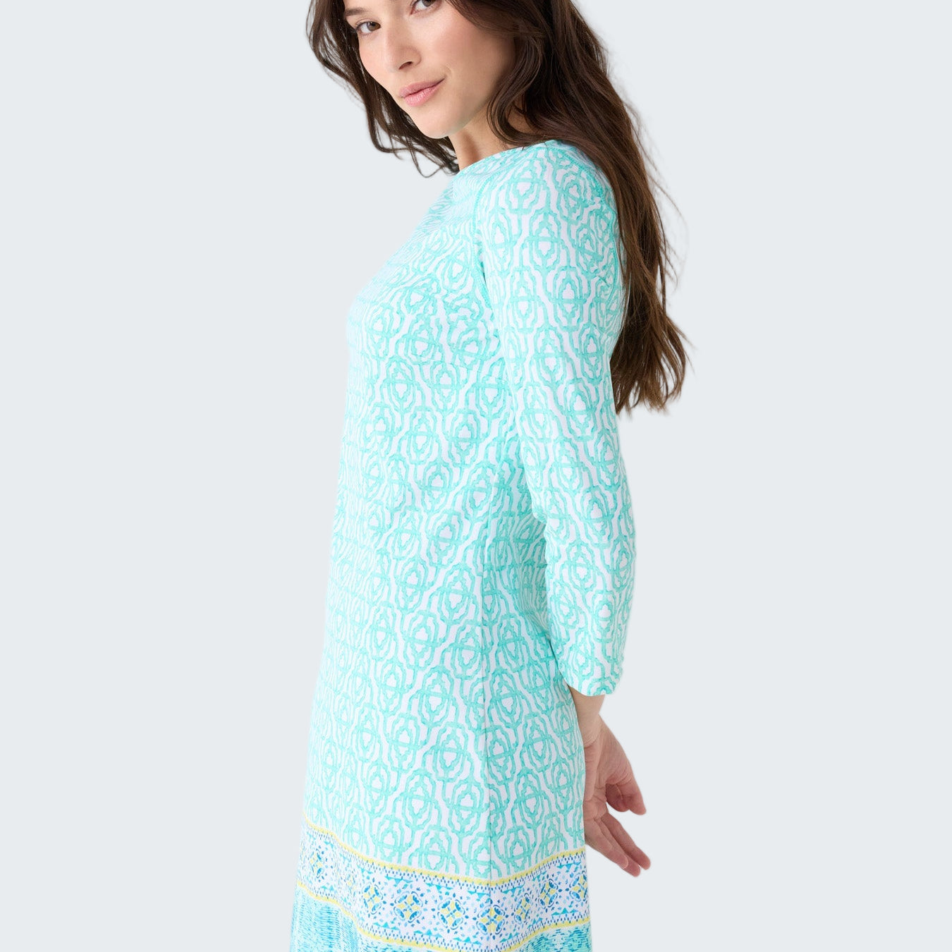 Woman wearing a light blue dress with a pattern on a white background