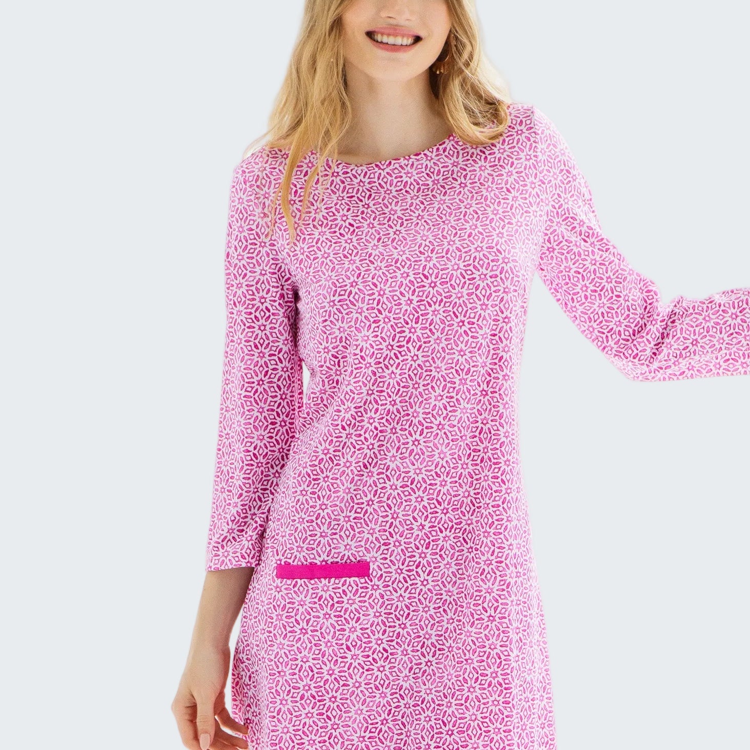 Woman wearing a pink patterned dress against a white background