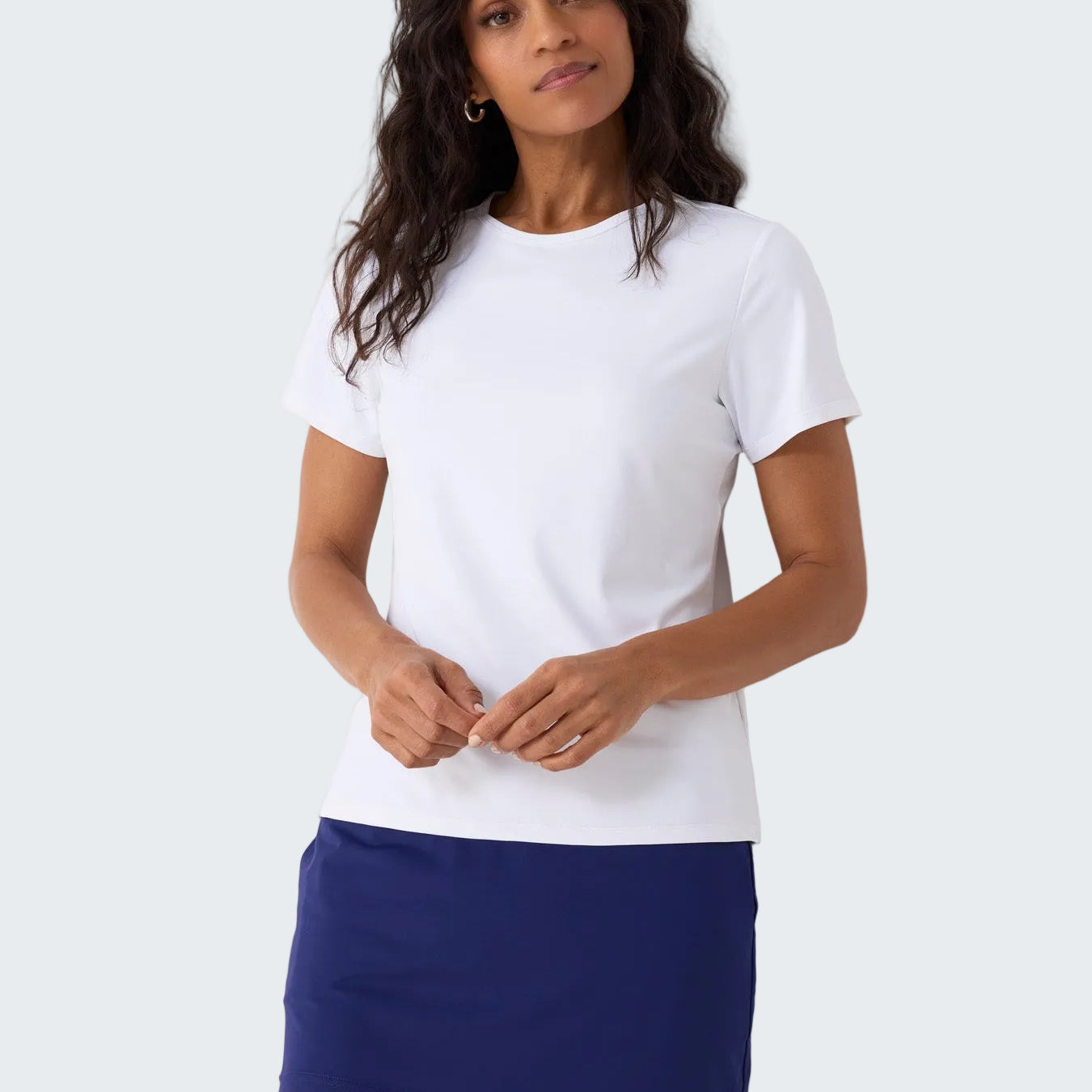 Woman wearing a white t-shirt and blue skirt against a white background