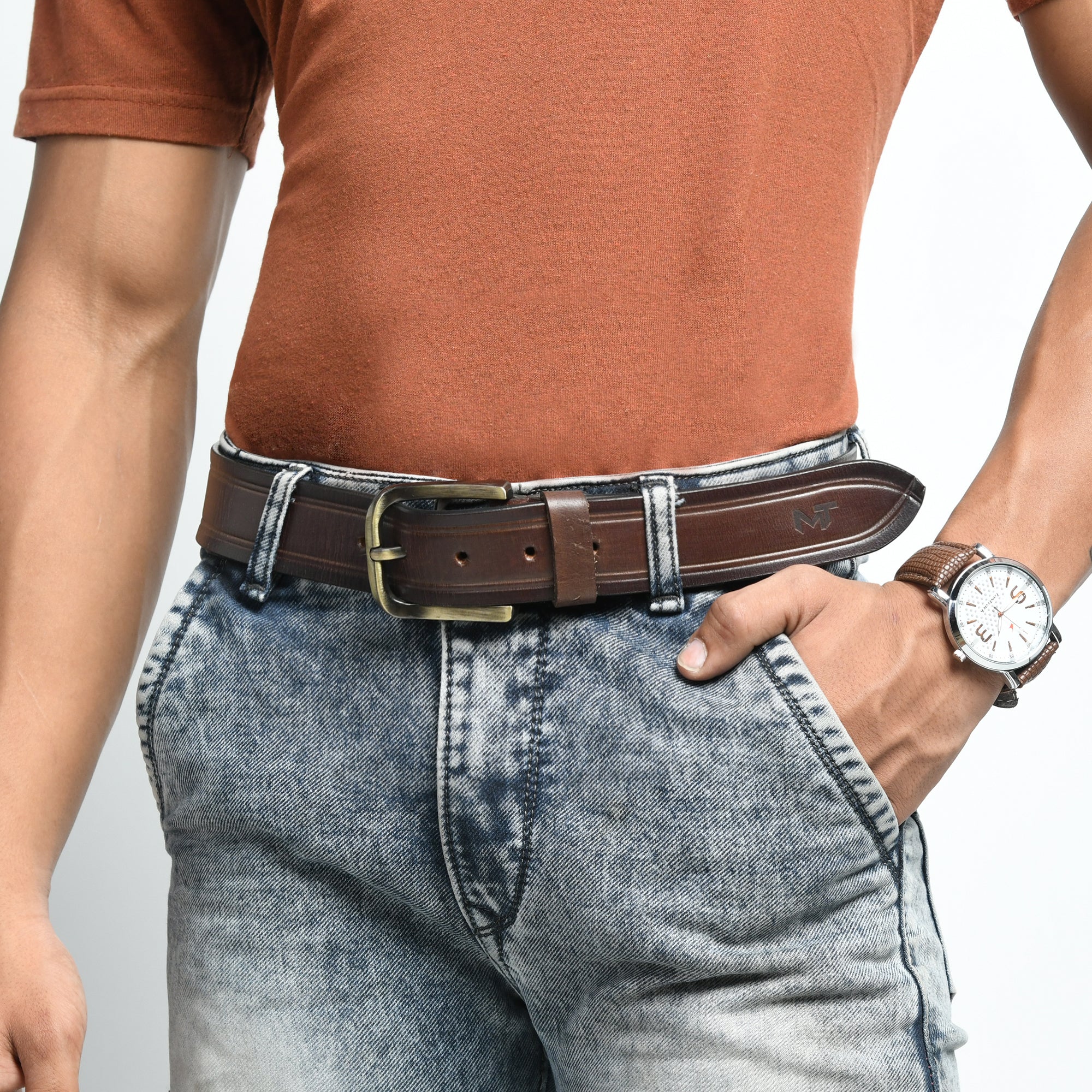 Person wearing a brown belt and watch with a neutral background