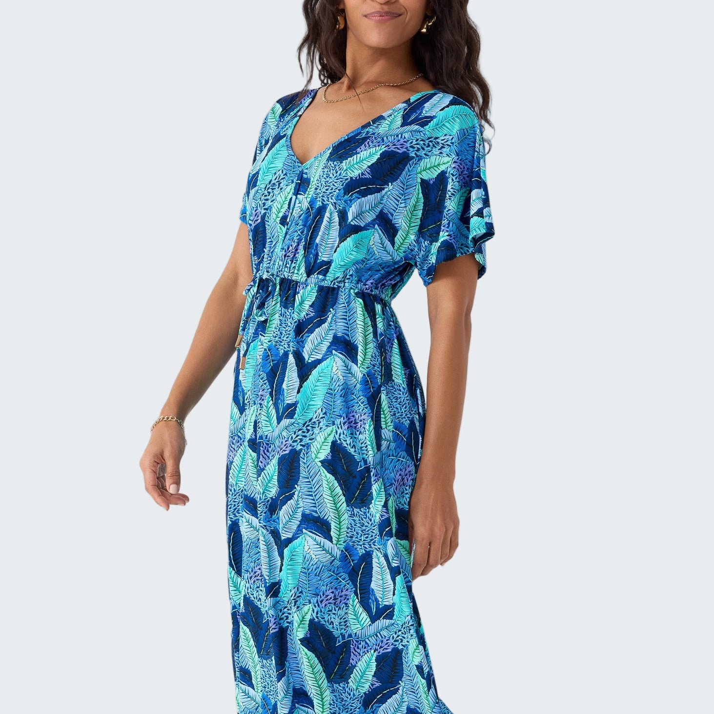 Woman wearing a blue and green patterned dress on a white background
