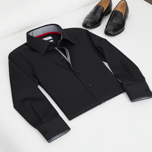 Black dress shirt with a red lining and two black shoes on a white surface