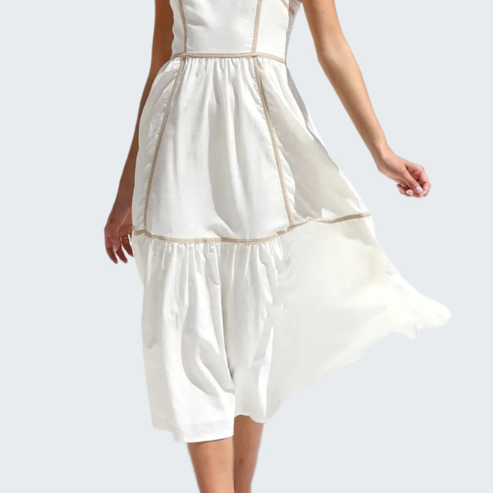 A woman wearing a white square neck midi cami dress with contrast trim, sleeveless, in a standing pose.