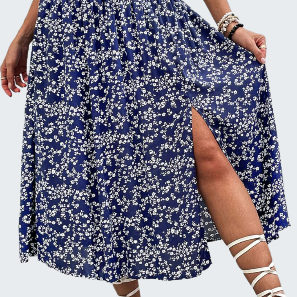 A high-waisted, floral print midi skirt with a slit, paired with white strappy sandals.