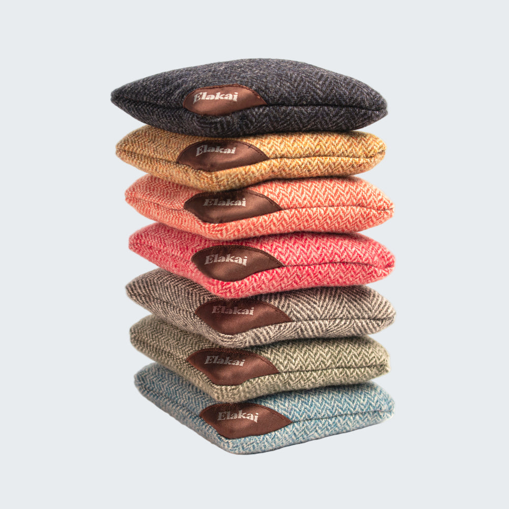 Stack of colorful fabric samples with 'Elakai' branding on a white background