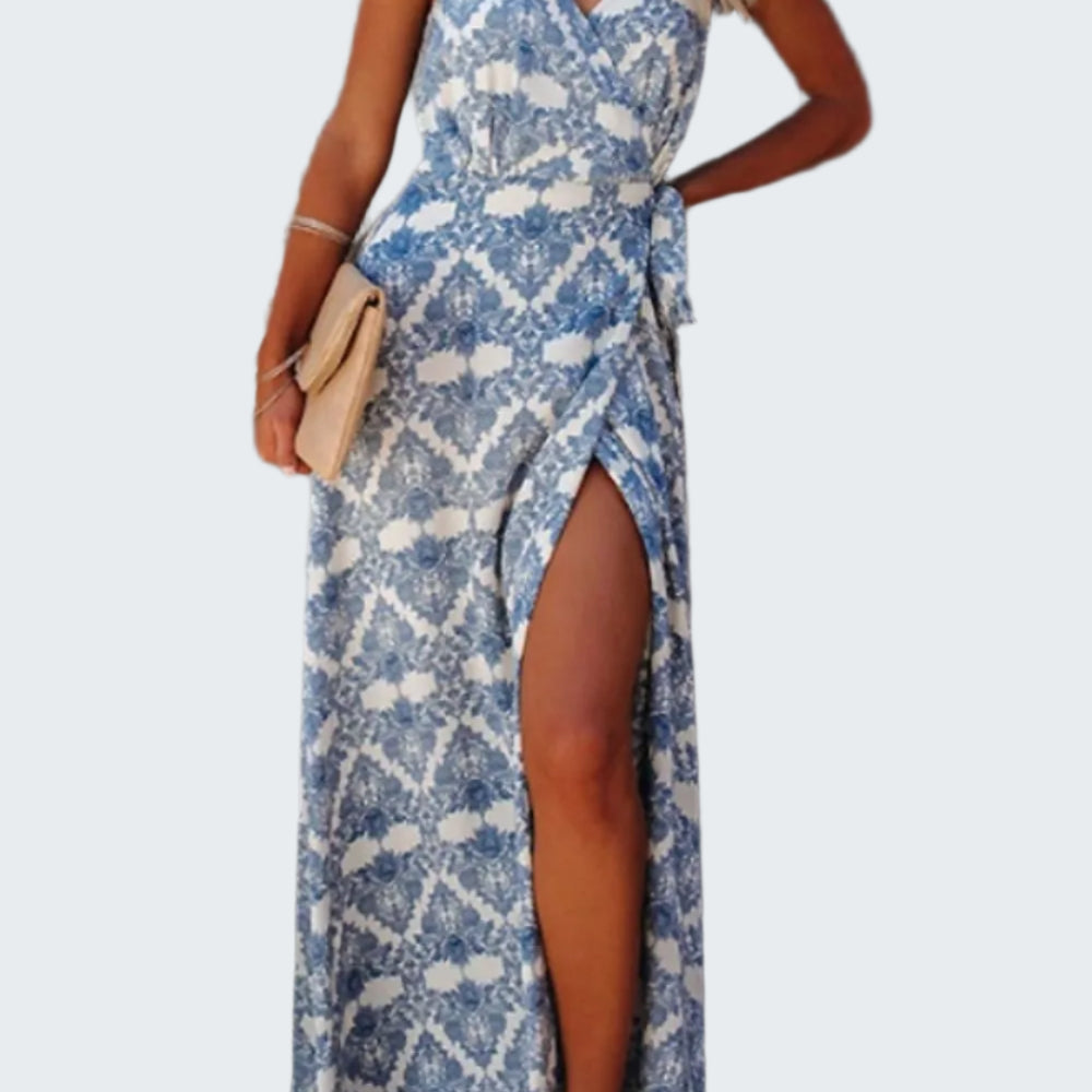 A tied maxi cami dress with a printed design, featuring a V-neckline and sleeveless design. The dress has a high slit on the left side.