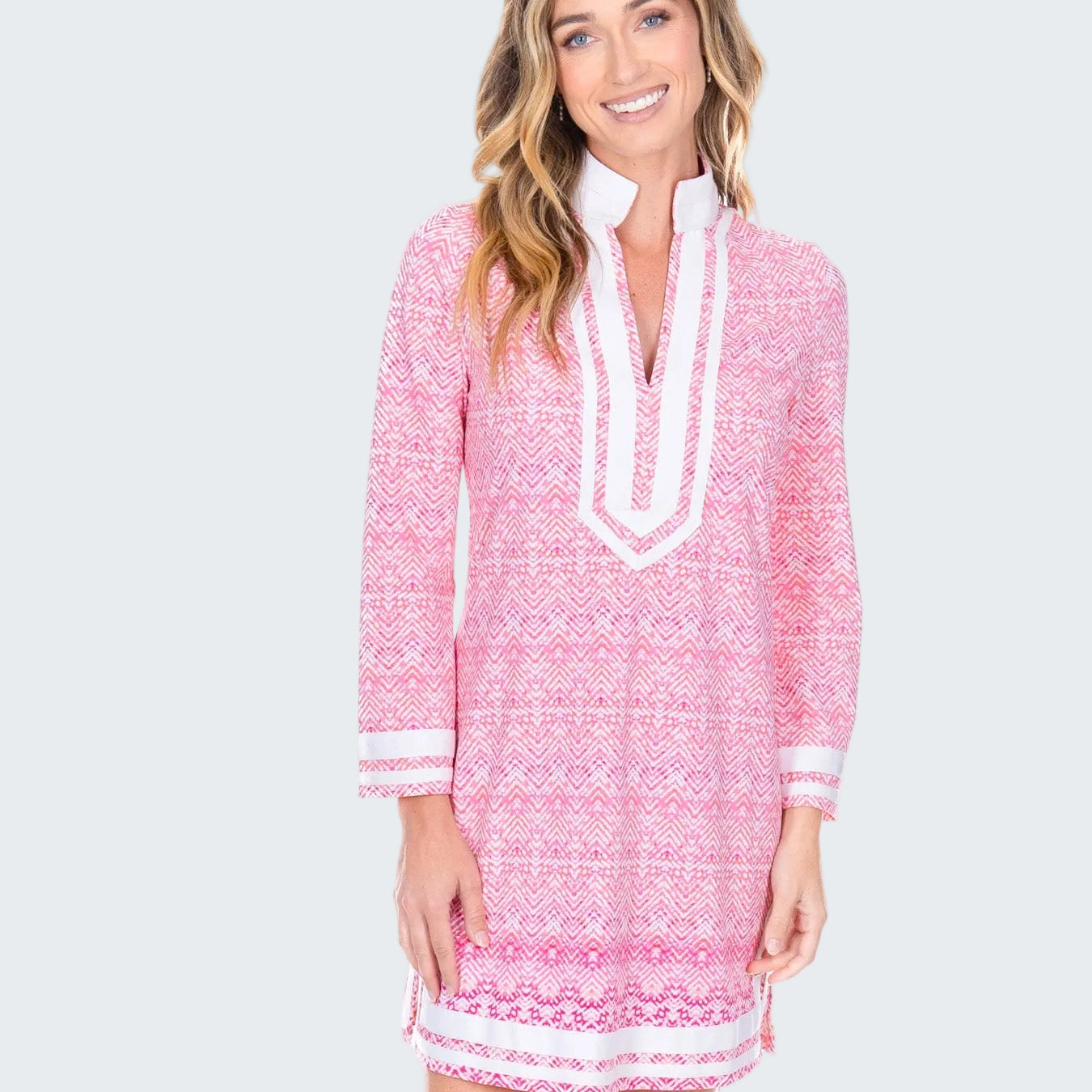 Woman wearing a pink and white patterned dress on a white background