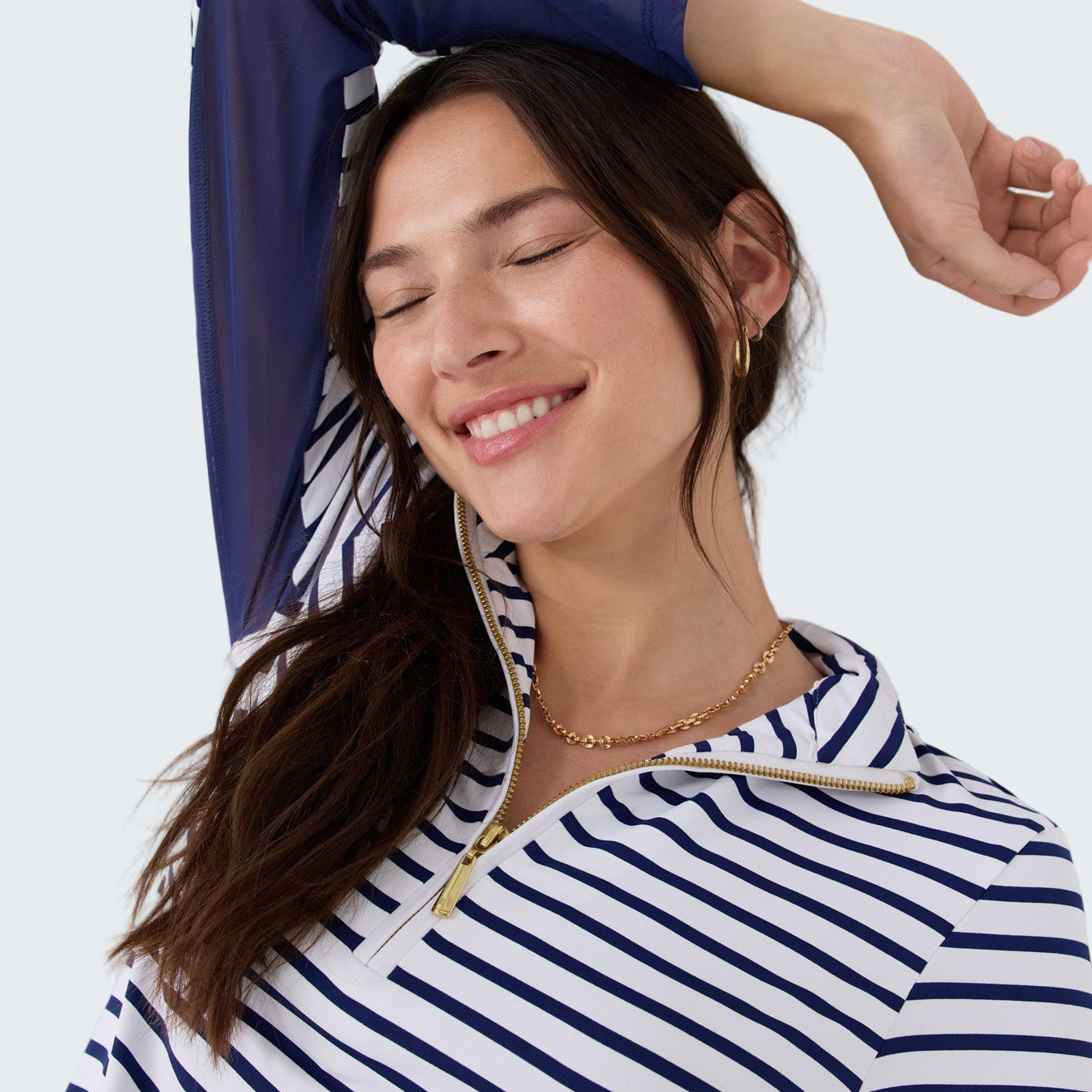 Woman wearing a blue and white striped shirt against a white background