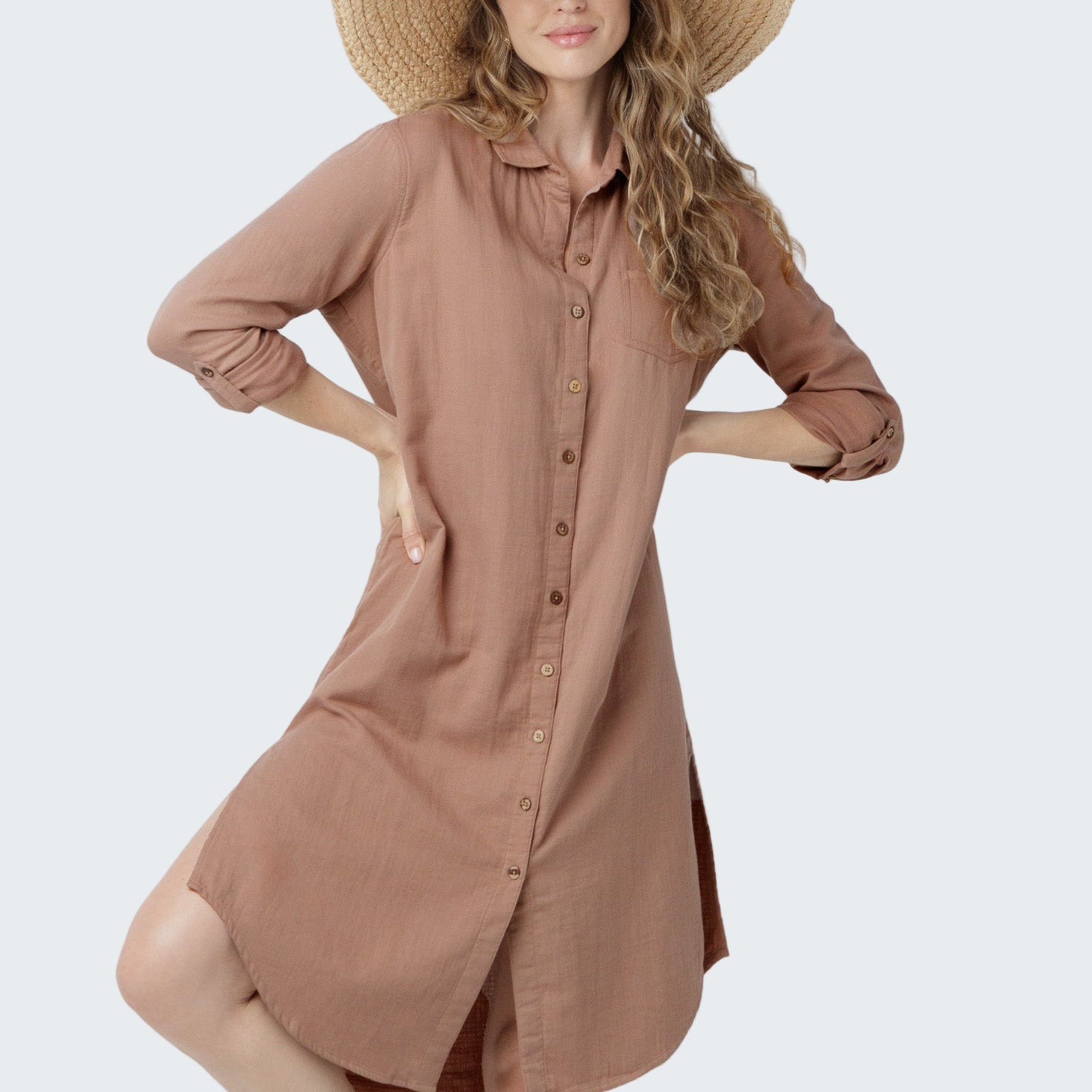 Woman wearing a brown dress and wide-brimmed hat on a white background