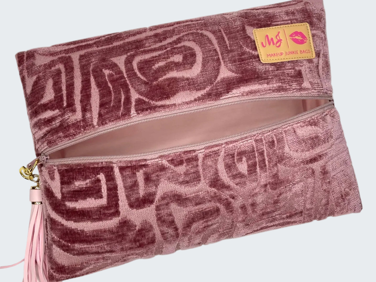 Pink patterned clutch bag with a visible brand label on a white background