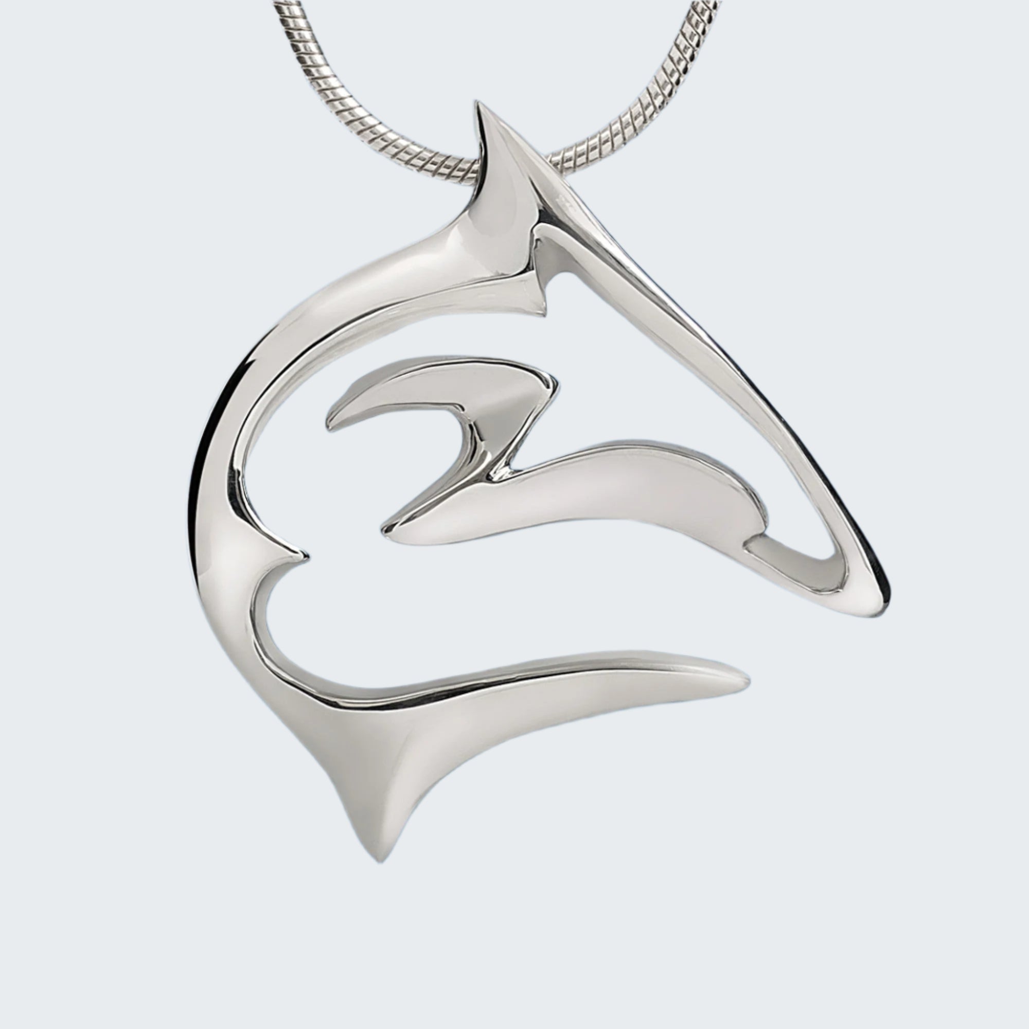 Silver pendant shaped like a wave on a blue water background