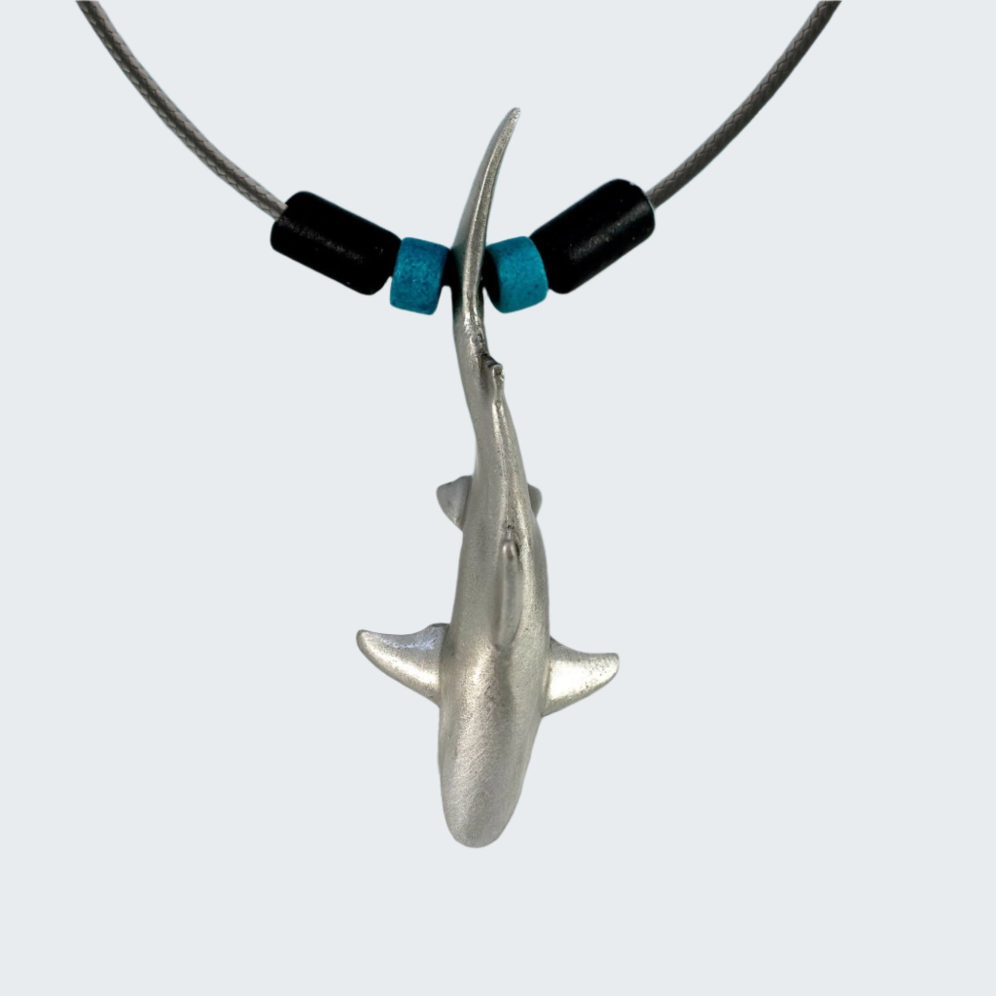 Shark necklace with ocean and beach background
