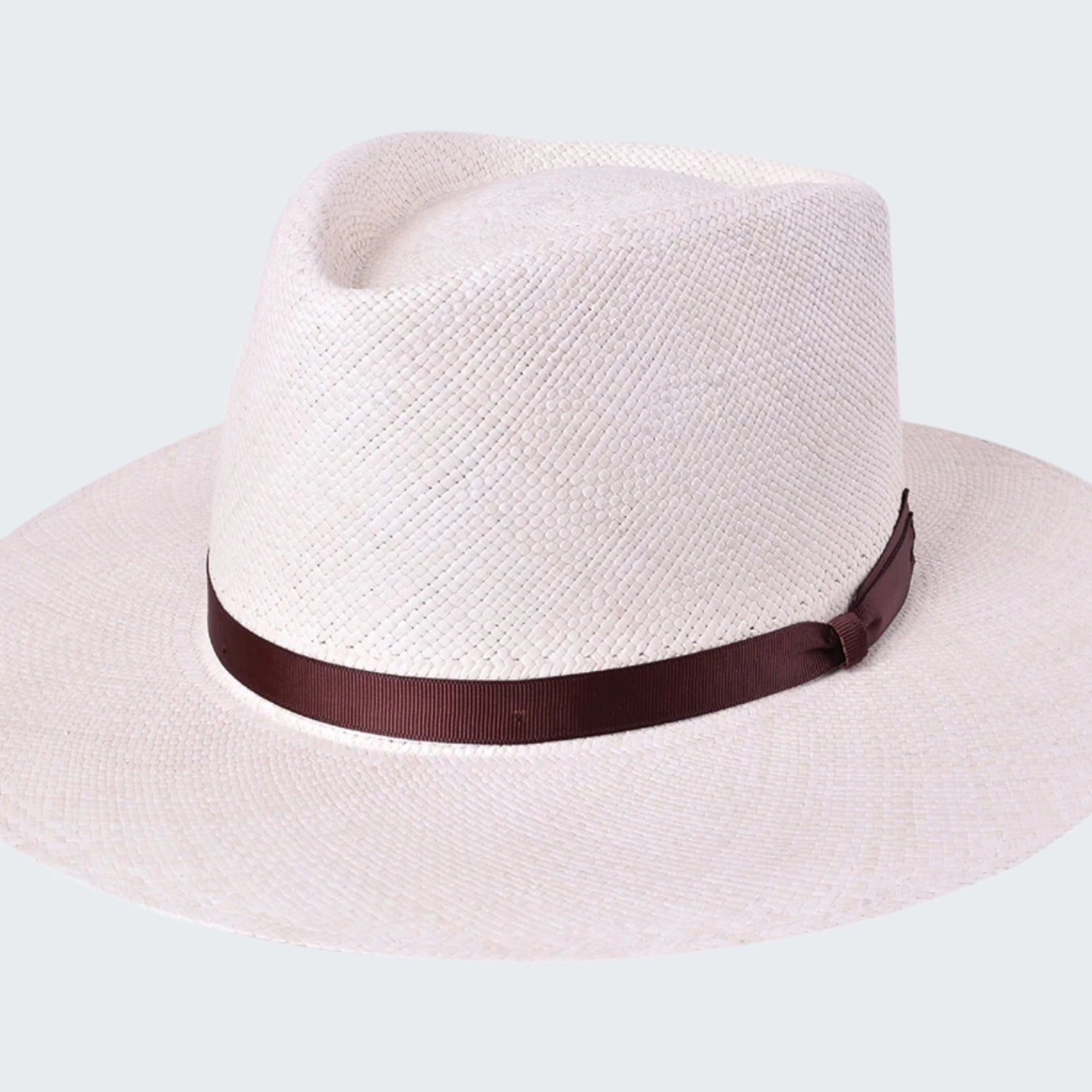 White straw hat with a brown band on a white background
