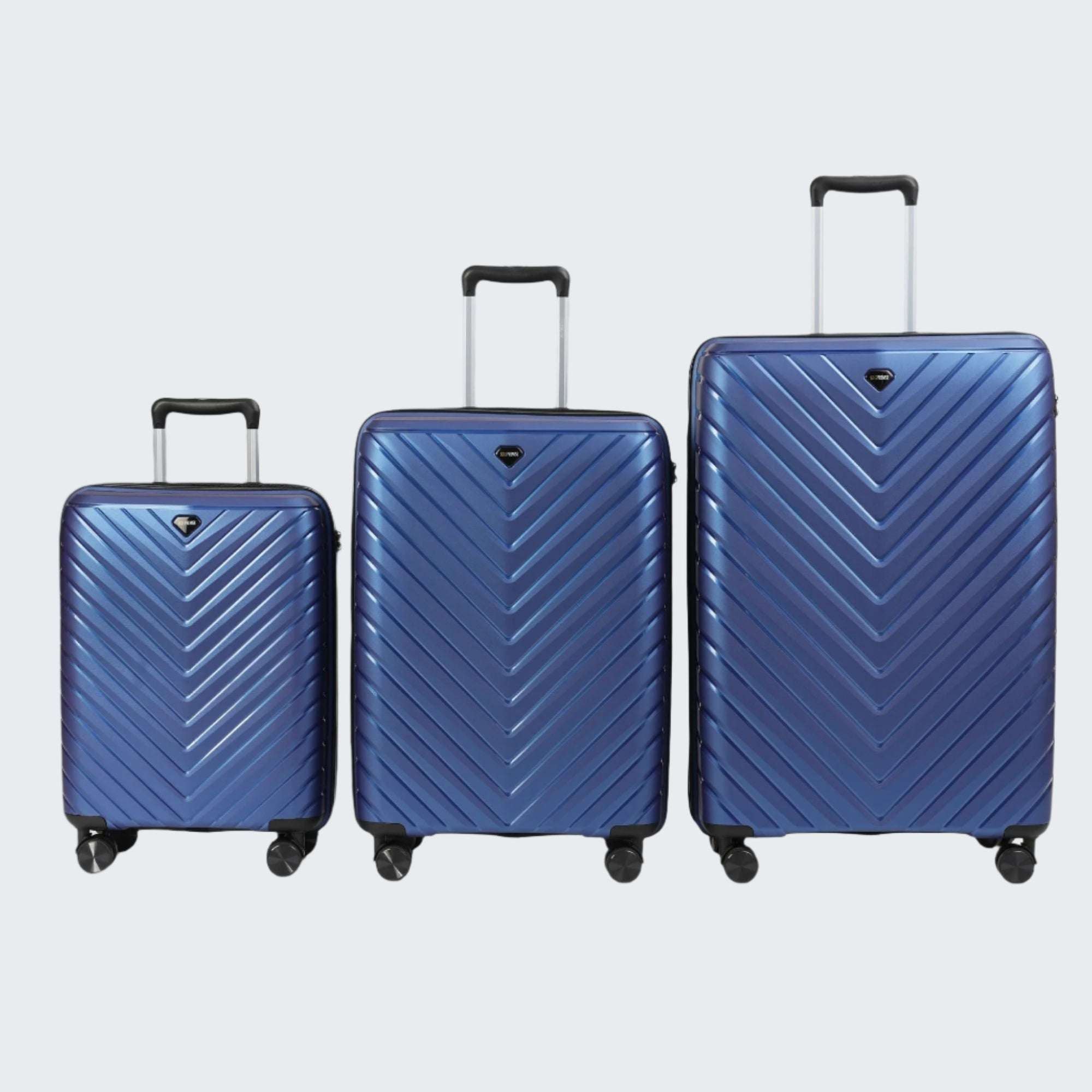 Three blue suitcases of different sizes on a gray background